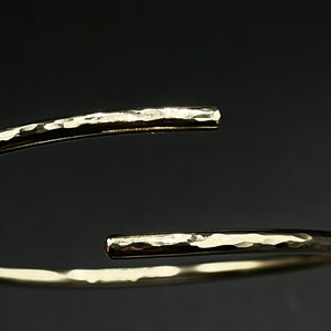 9ct Yellow gold adjustable, cross-over Bangle. Round wire hammered, polished finish